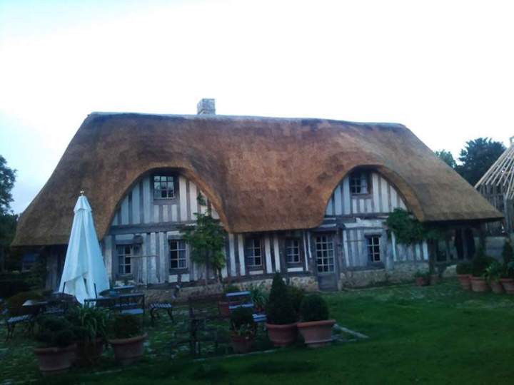 Maison traditionnelle à colombages avec toit de chaume Normandie